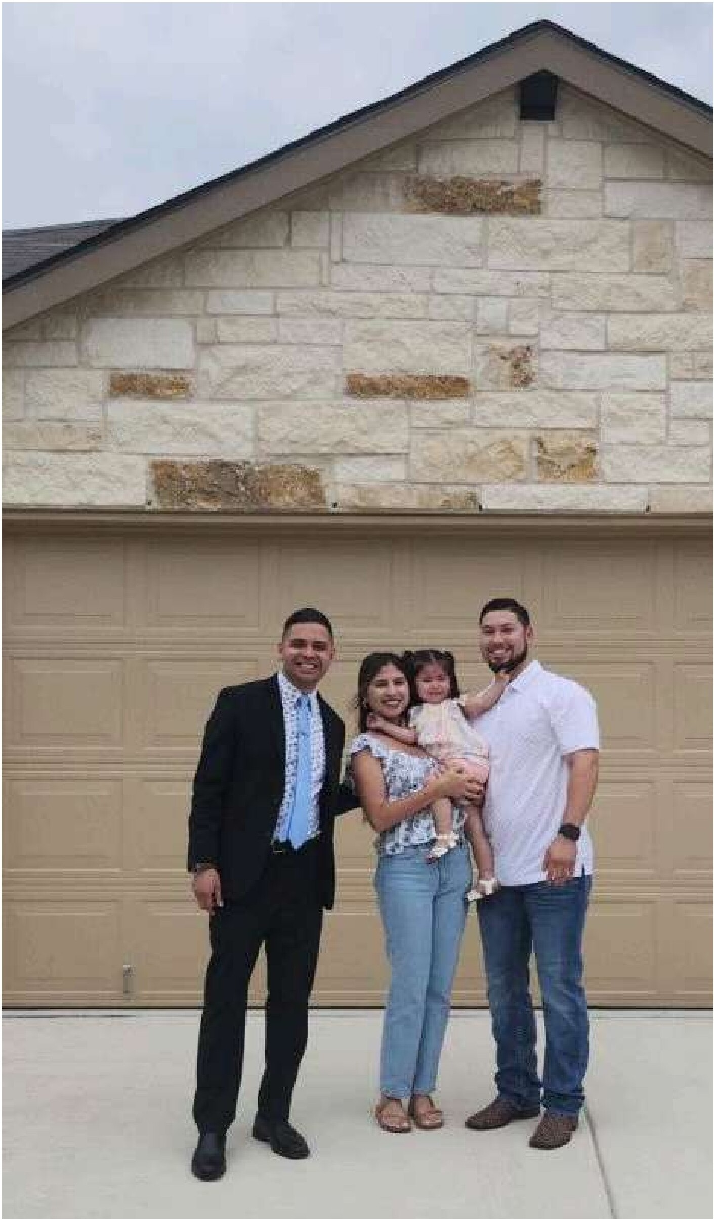 Family standing in front of their new home